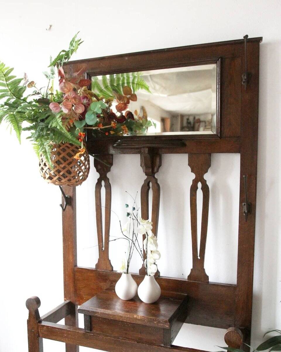 Antique brown wooden coat rack with mirror and umbrella stand, 1900 style.