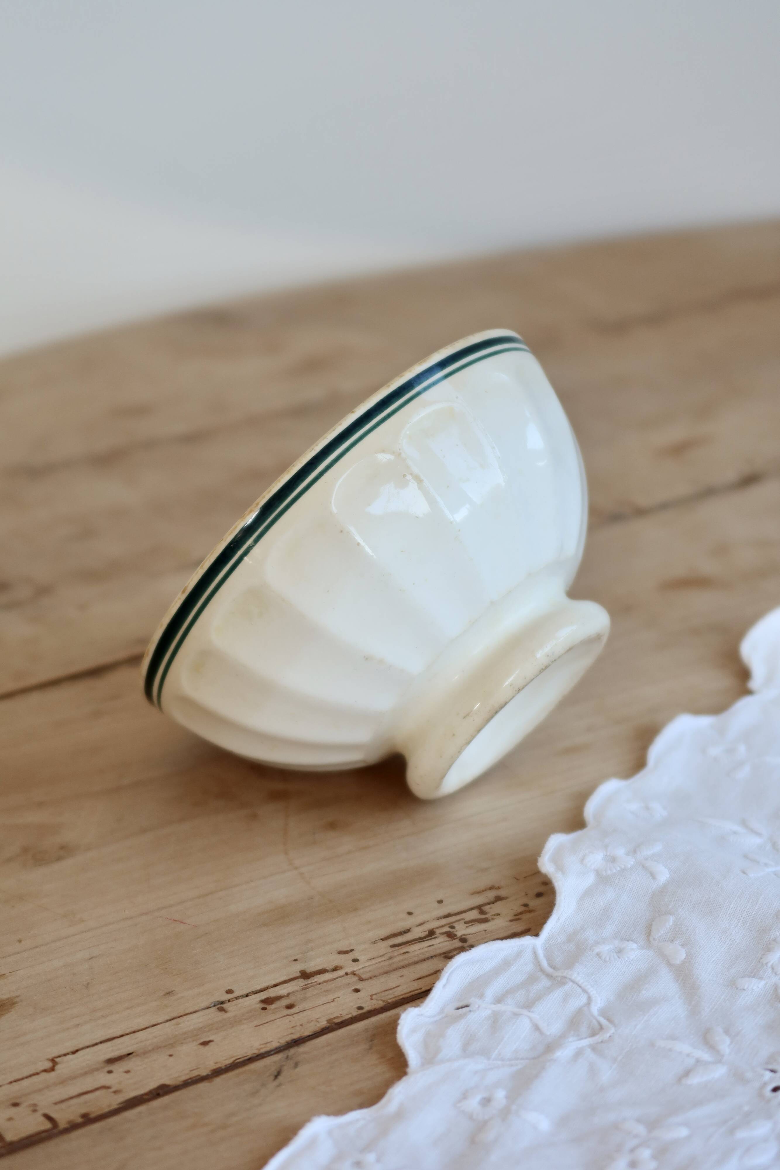 Old ivory ceramic bowl with double green trim.