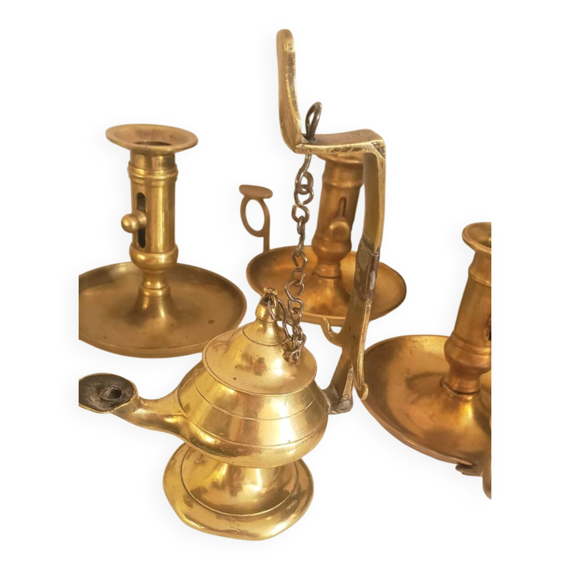 Many candlesticks and a small oil lamp.