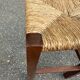 Low stool in brutalist style made of solid wood with straw, 1980.