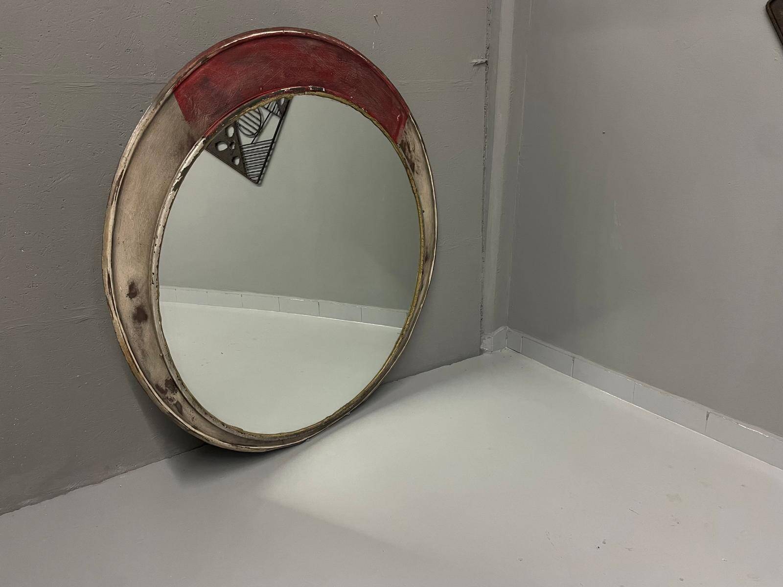 Vintage round mirror with an industrial metal frame in a painted finish.
