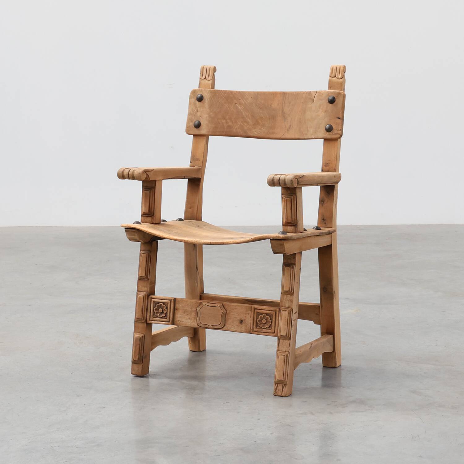 Brutalist armchair with carved rosettes and nailed wooden seat, Spain