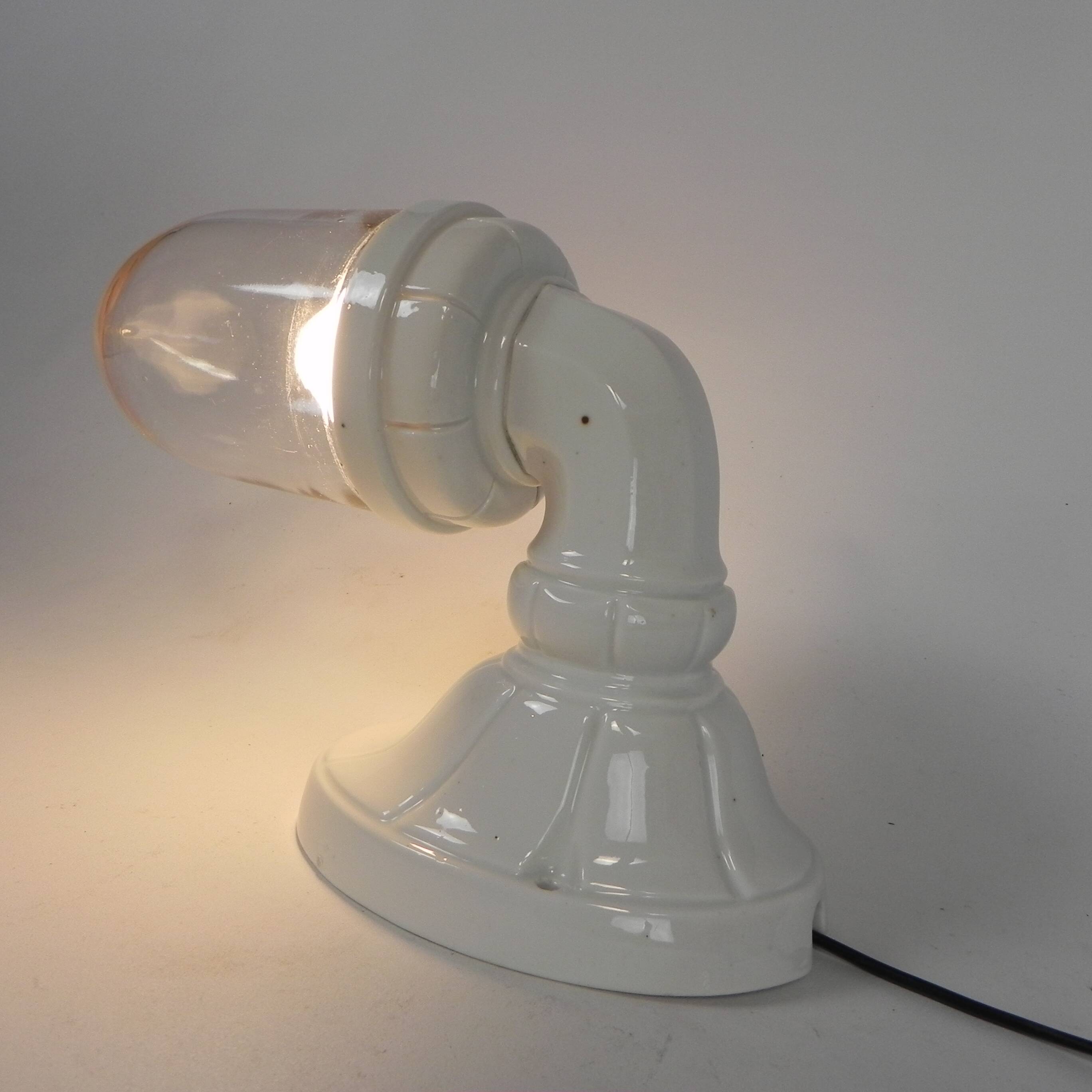 Wall lamp in porcelain with a transparent glass shade, 1930s.
