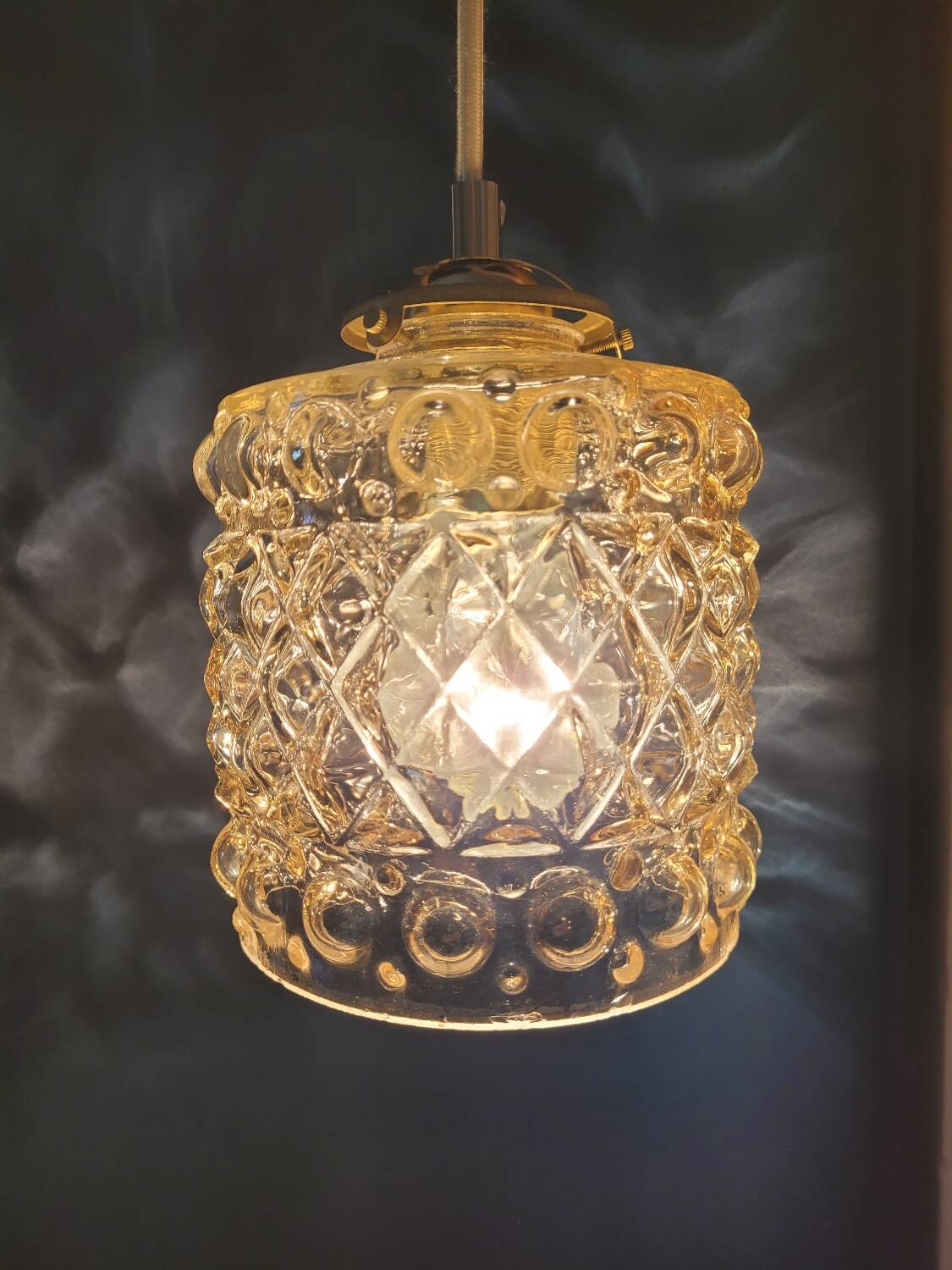 Moulded glass lamp with a cubic-spherical relief design.