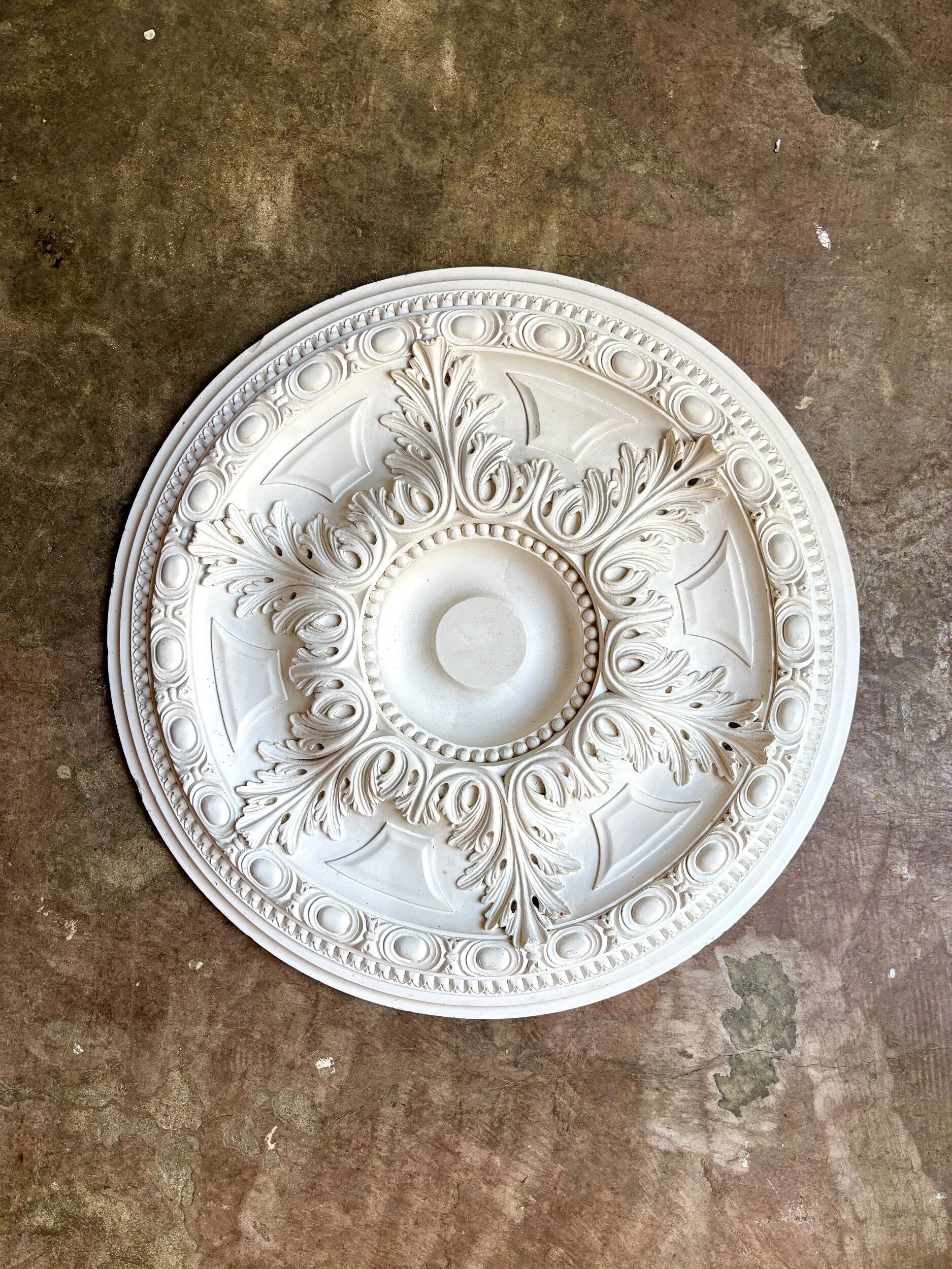 Rosette on white background, decorated with scrolls and beaded frieze ⌀ 61 cm