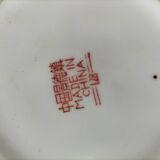 Vintage Chinese teapot with floral polychrome decoration on a black background.