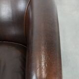 Dark brown vintage club armchair in English style made of sheepskin leather