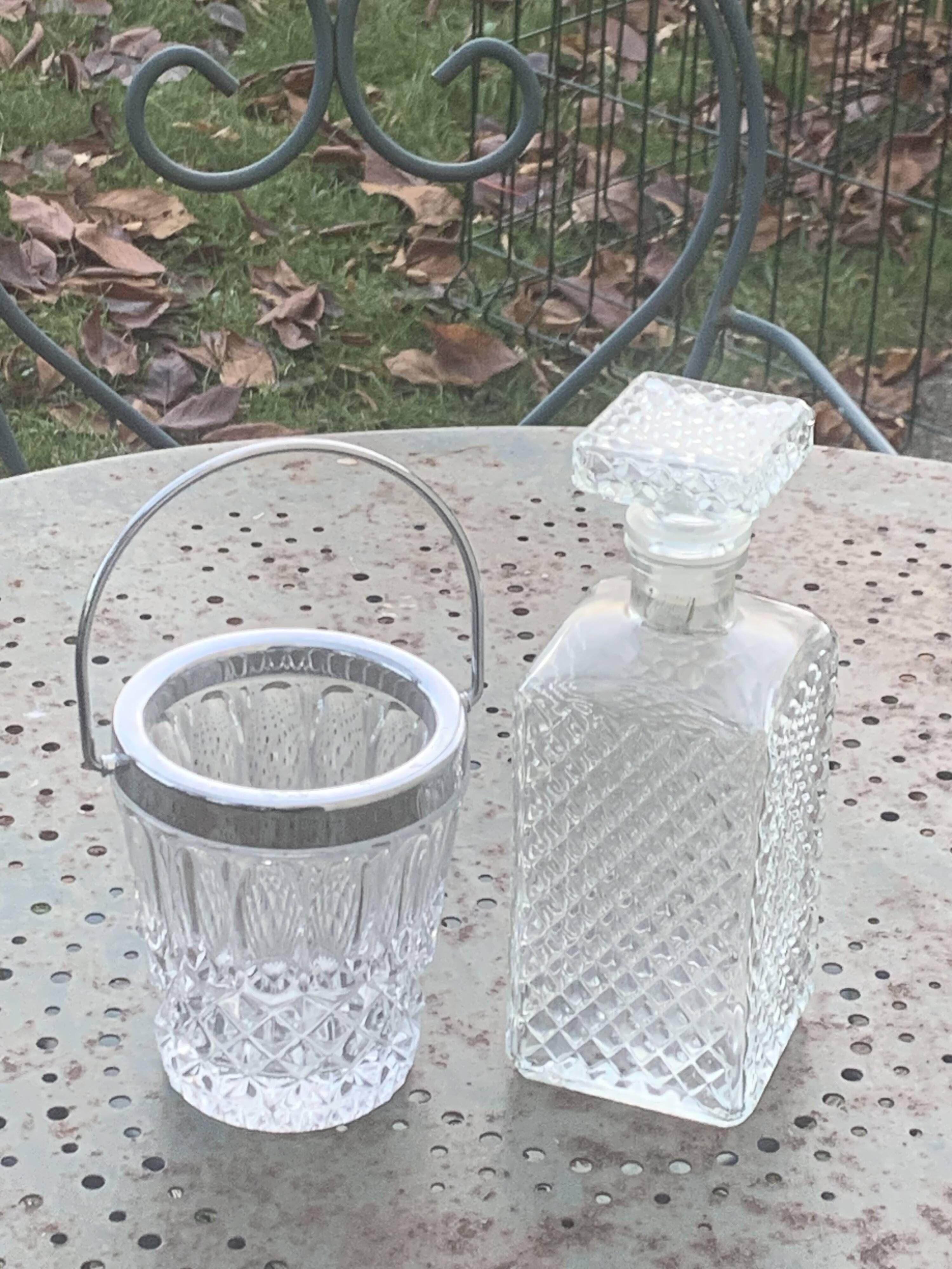 Whiskey carafe and ice bucket in transparent glass and silver-colored metal handle