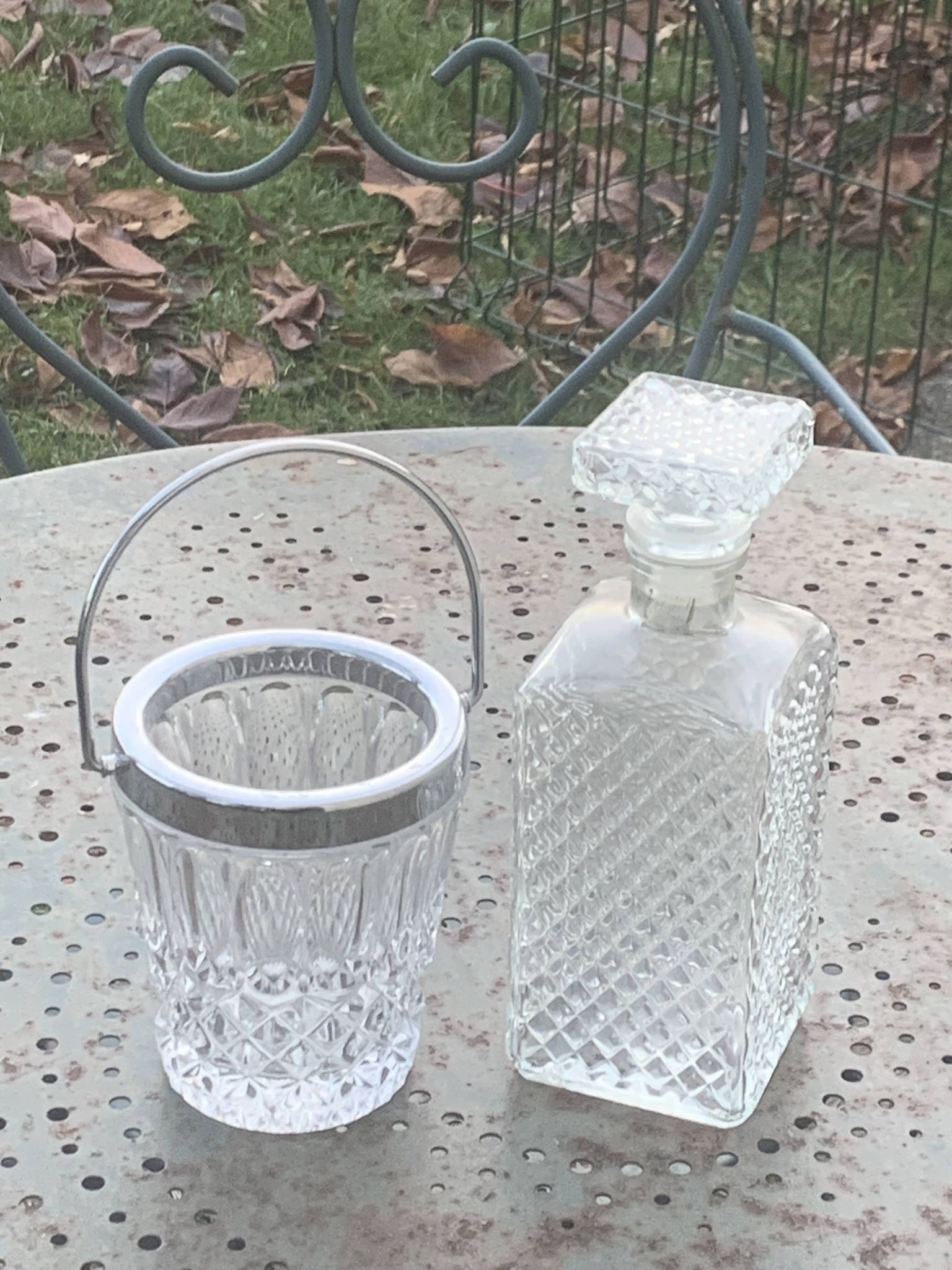 Whiskey carafe and ice bucket in transparent glass and silver-colored metal handle
