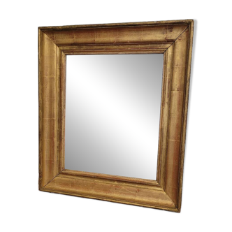 Almost square mirror in wood and gilded stucco.