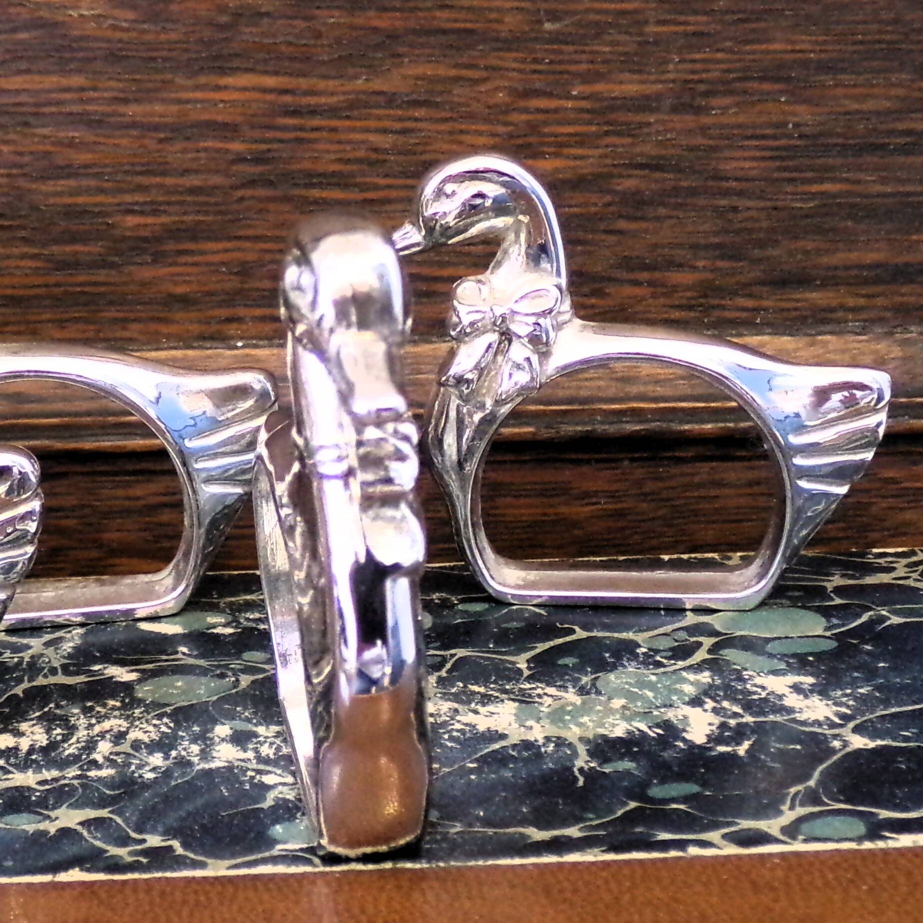 Four silver-plated napkin rings in the shape of a duck/goose