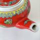 Vintage red Chinese teapot decorated with dragons and symbols.