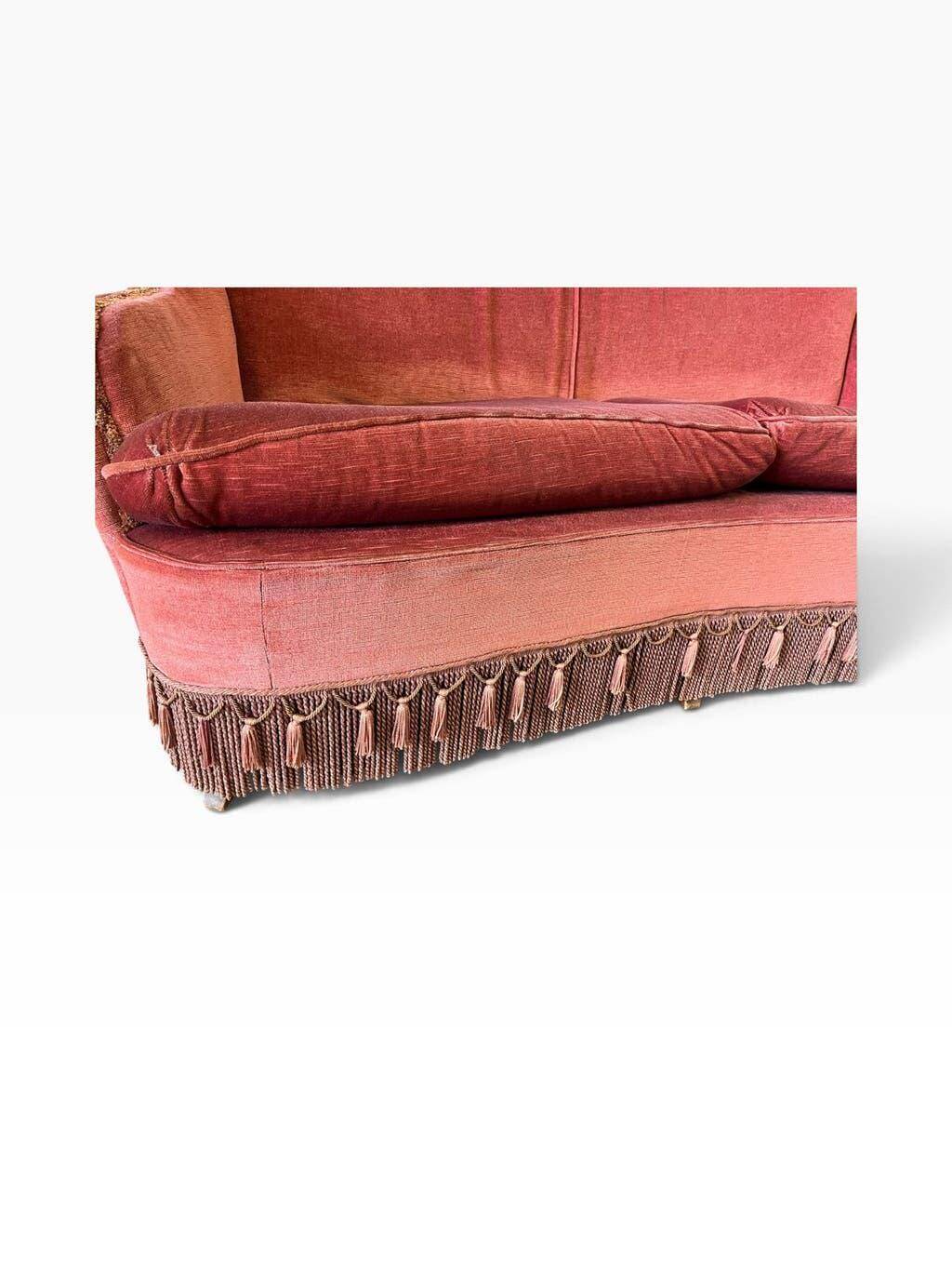 Vintage two-seater armchair in powder pink velvet with fringes.