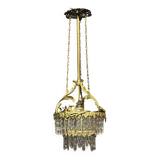 Antique chandelier in gilded bronze with crystal pendants.