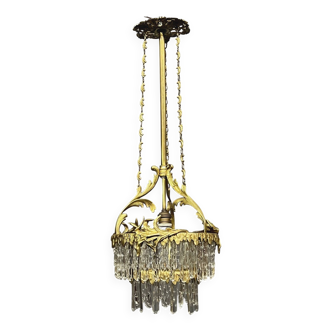 Antique chandelier in gilded bronze with crystal pendants.
