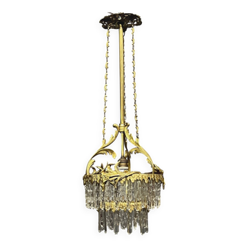 Antique chandelier in gilded bronze with crystal pendants.