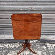 19th-century solid mahogany table with a tilting top and brass mechanism.