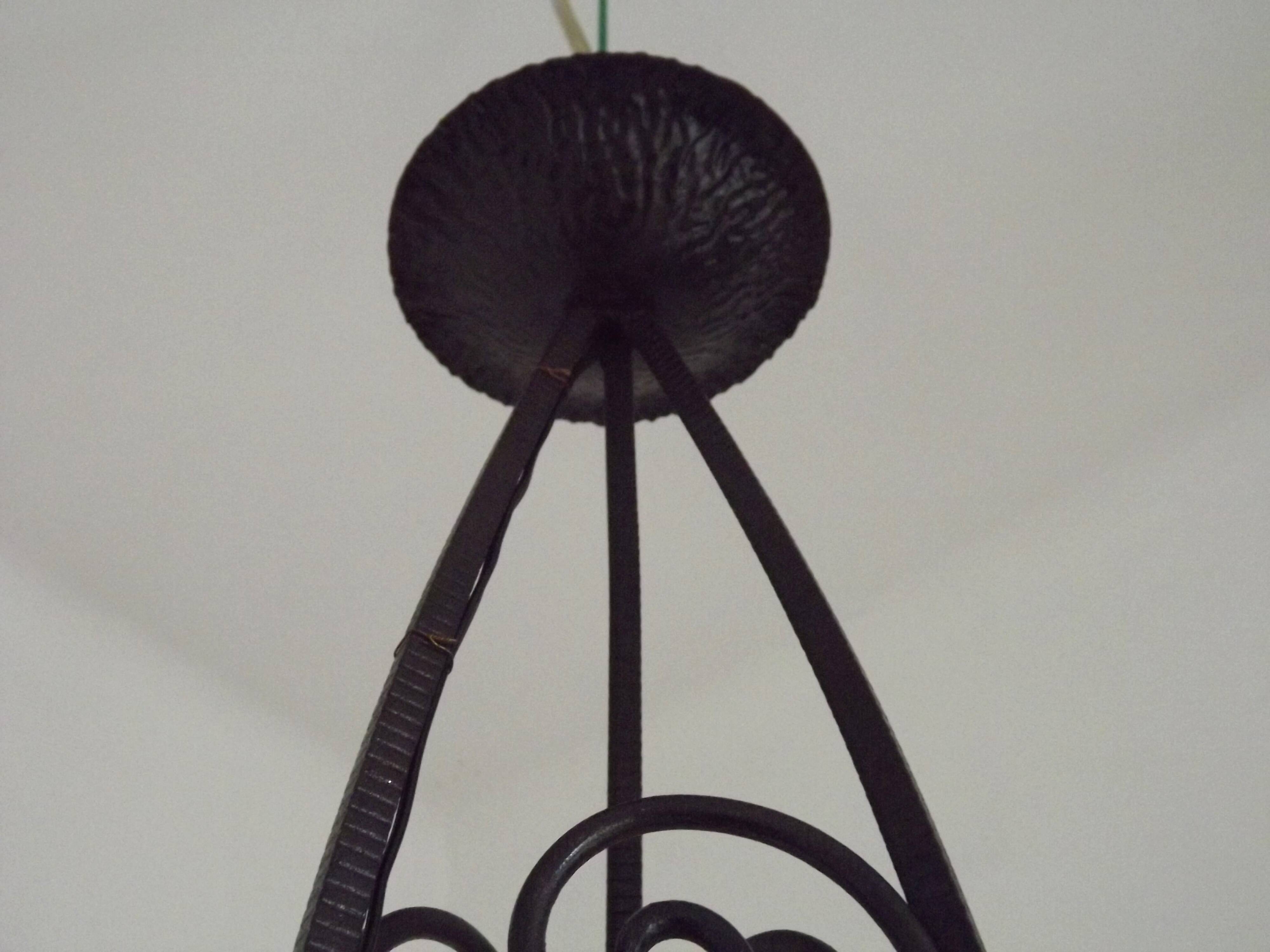 French Art Nouveau leaf detail iron three-light chandelier with amber glass shades.