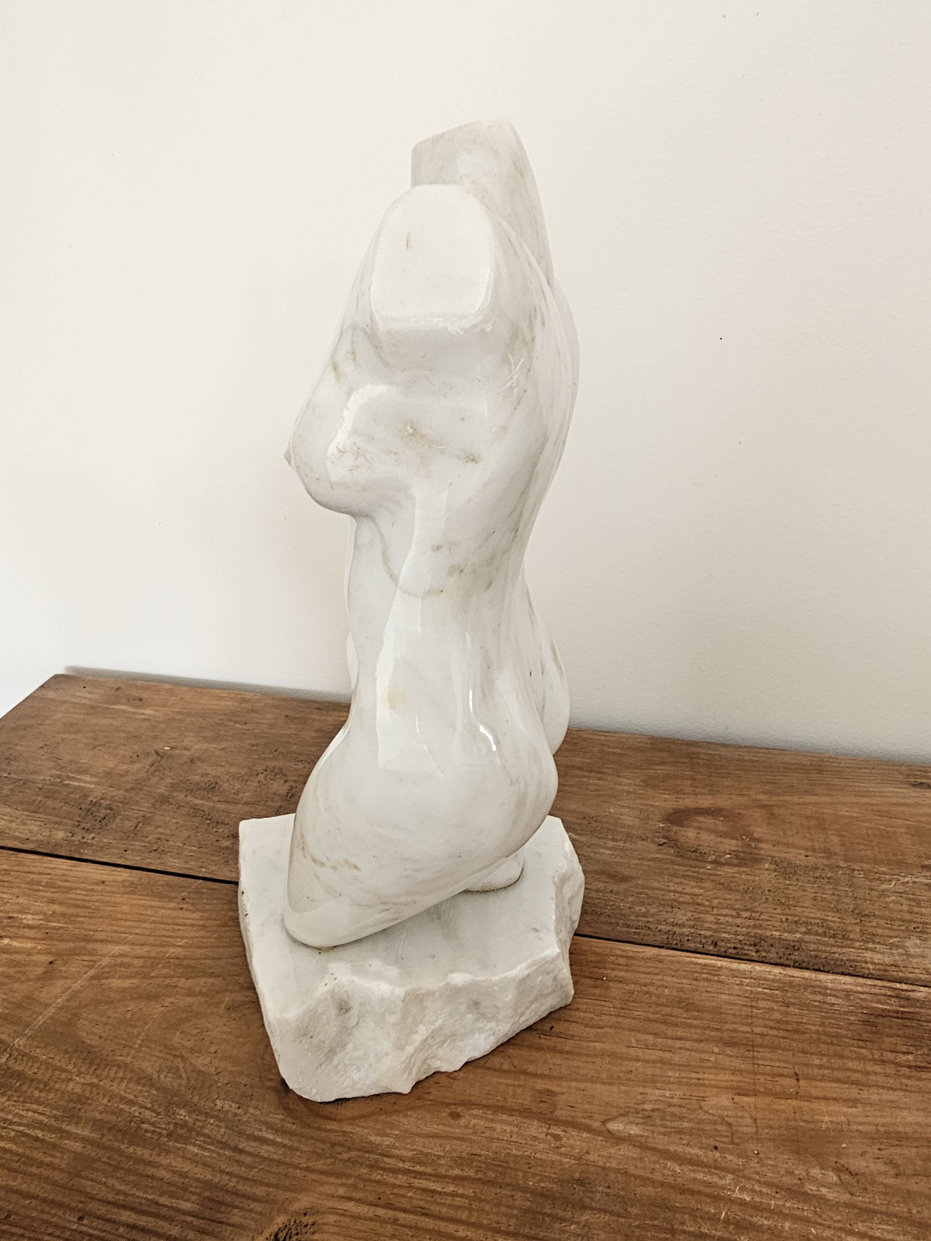 Sculpture of a female torso in white marble.