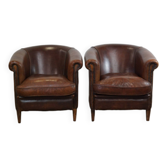 Ensemble de deux fauteuils club en cuir de mouton robuste avec un joli look vieilli