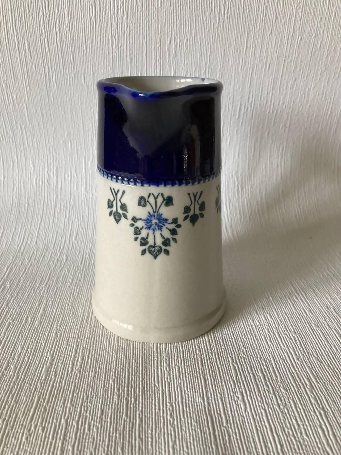 Pichet Saint-Uze en terre d’acier bleu, blanc et à décor floral