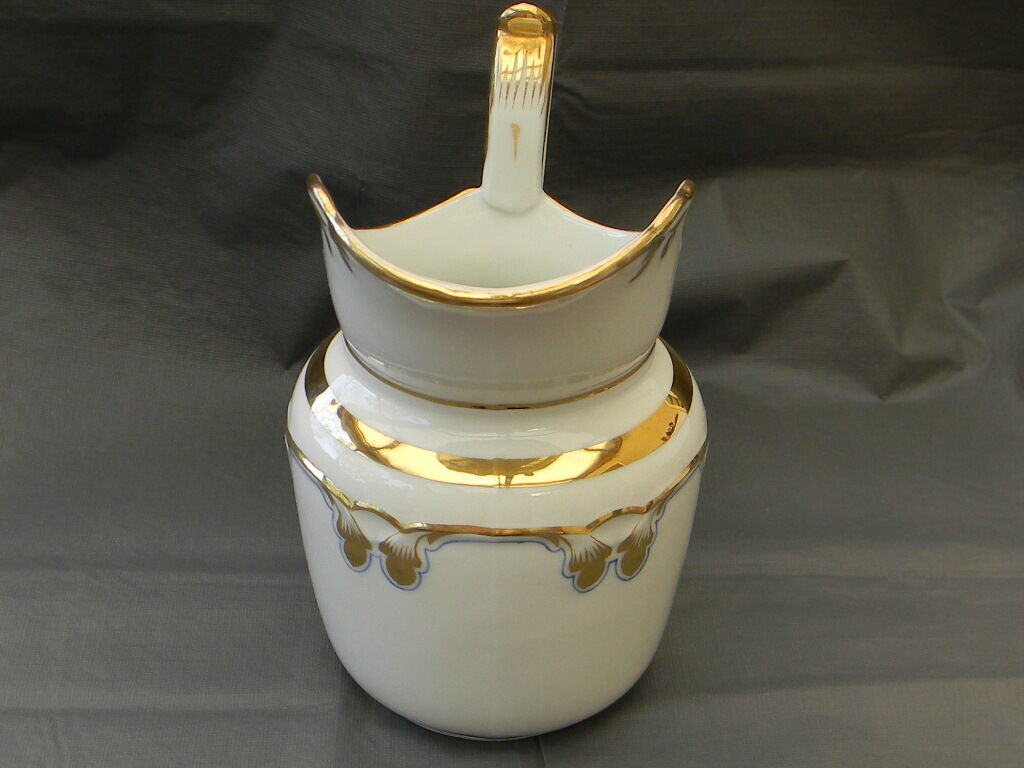 Milk jug or antique pitcher in white and gold porcelain.