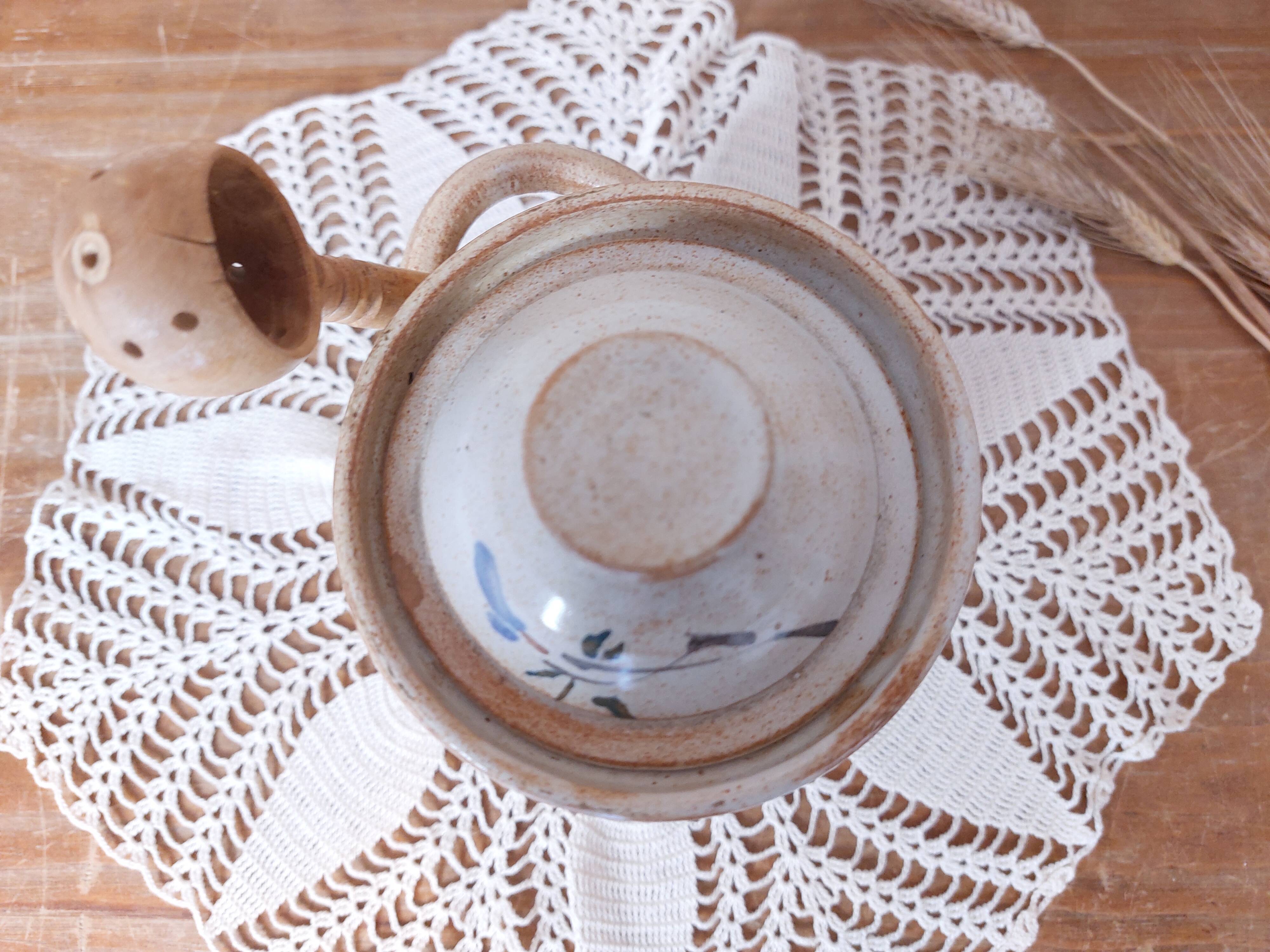 Old large vintage stoneware olive pot with its wooden spoon