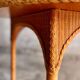 Natural Lloyd Loom paper cord rattan round table with brass-capped legs by Vincent Sheppard