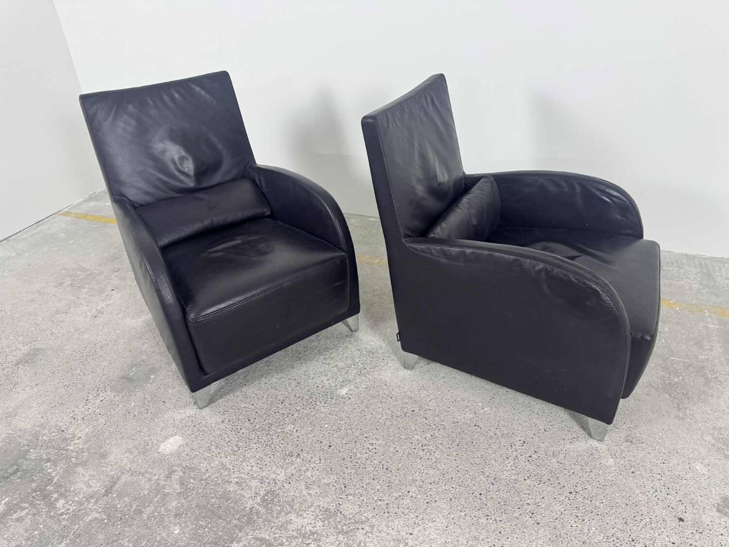 Pair of aubergine leather club armchairs by Cinna.