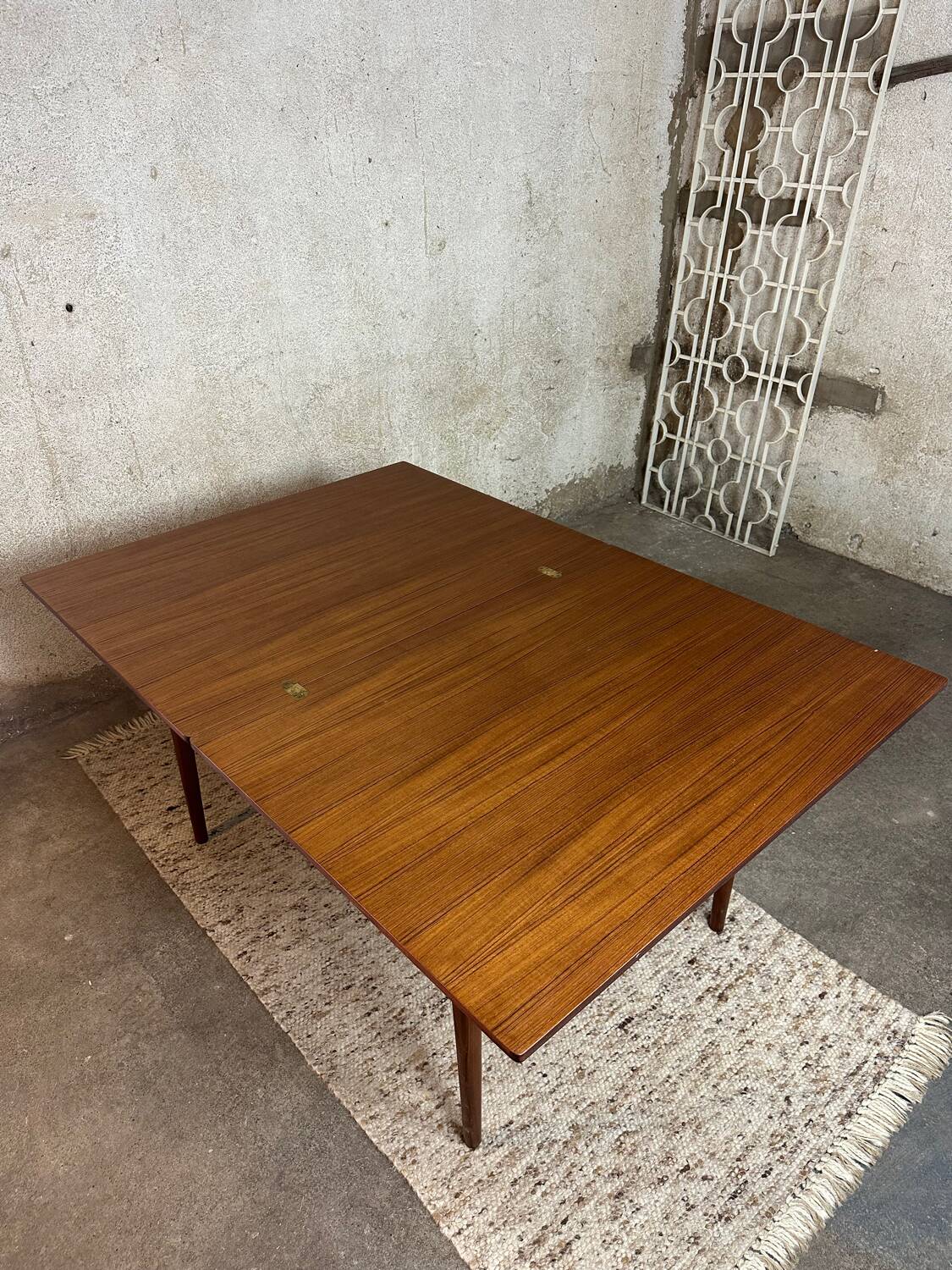 Extendable teak and teak veneer dining table