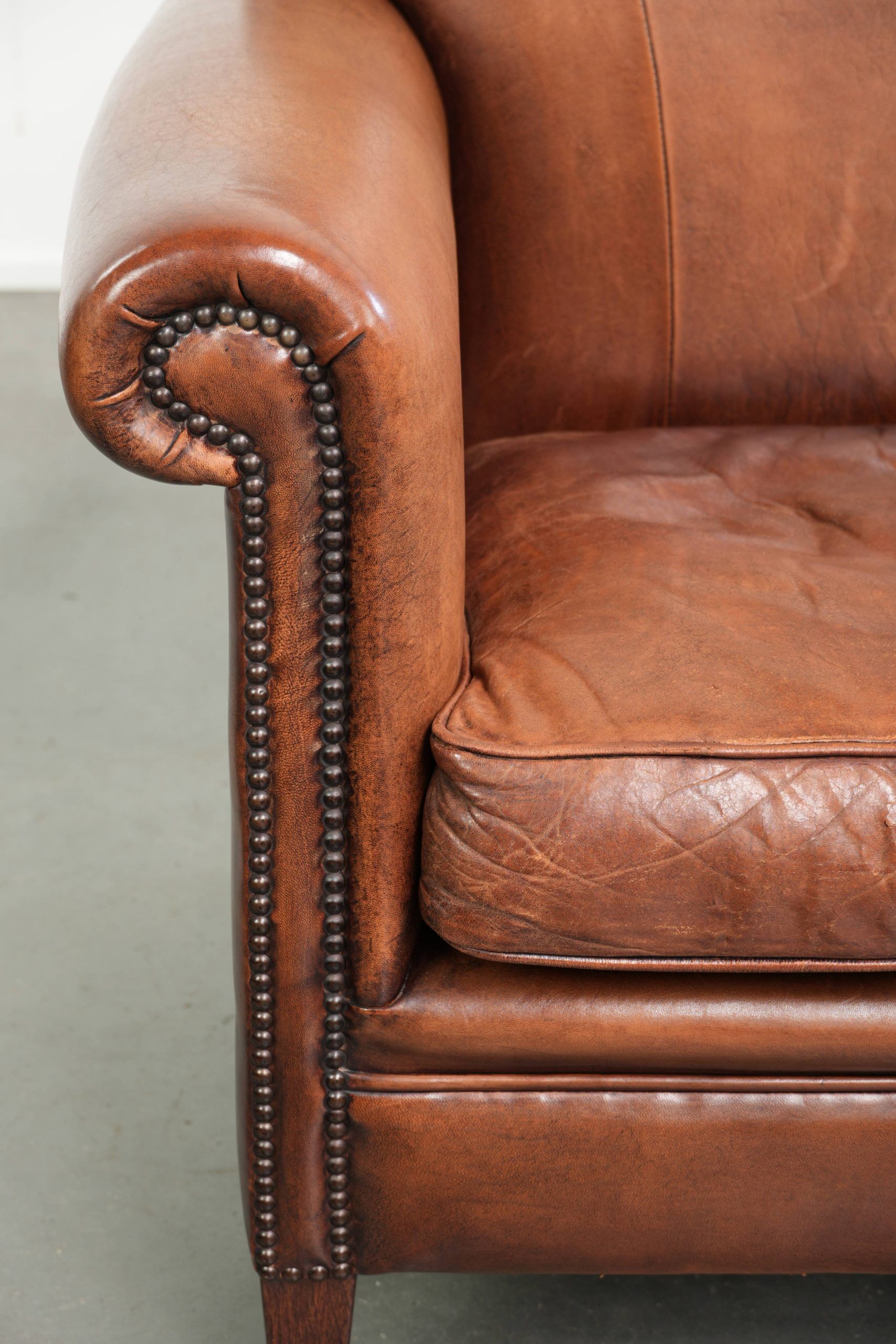 Sheepskin armchair with comfortable seat and finished with decorative nails