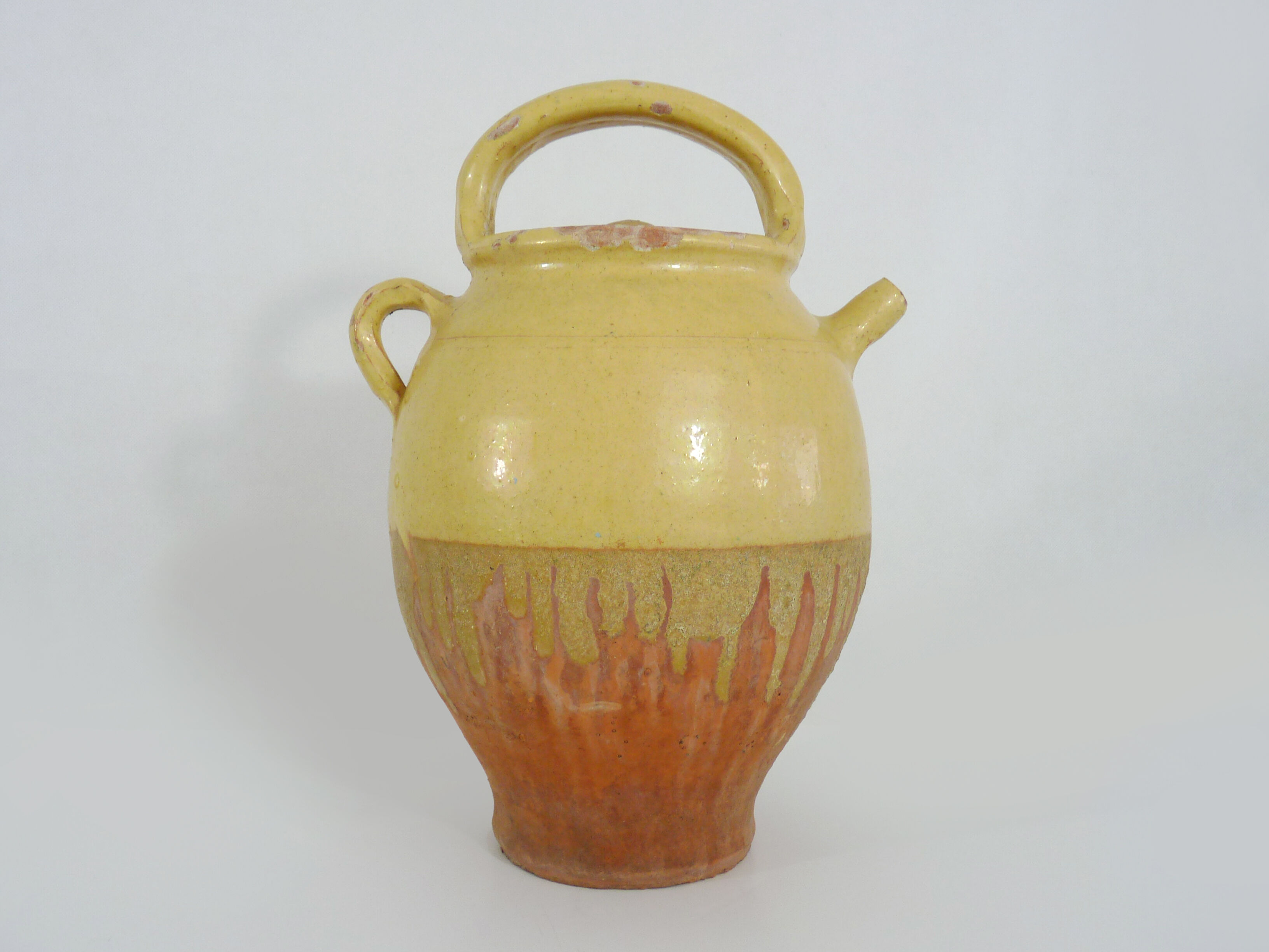 Old jug, chevrette, water pitcher in glazed yellow sandstone. Early twentieth century