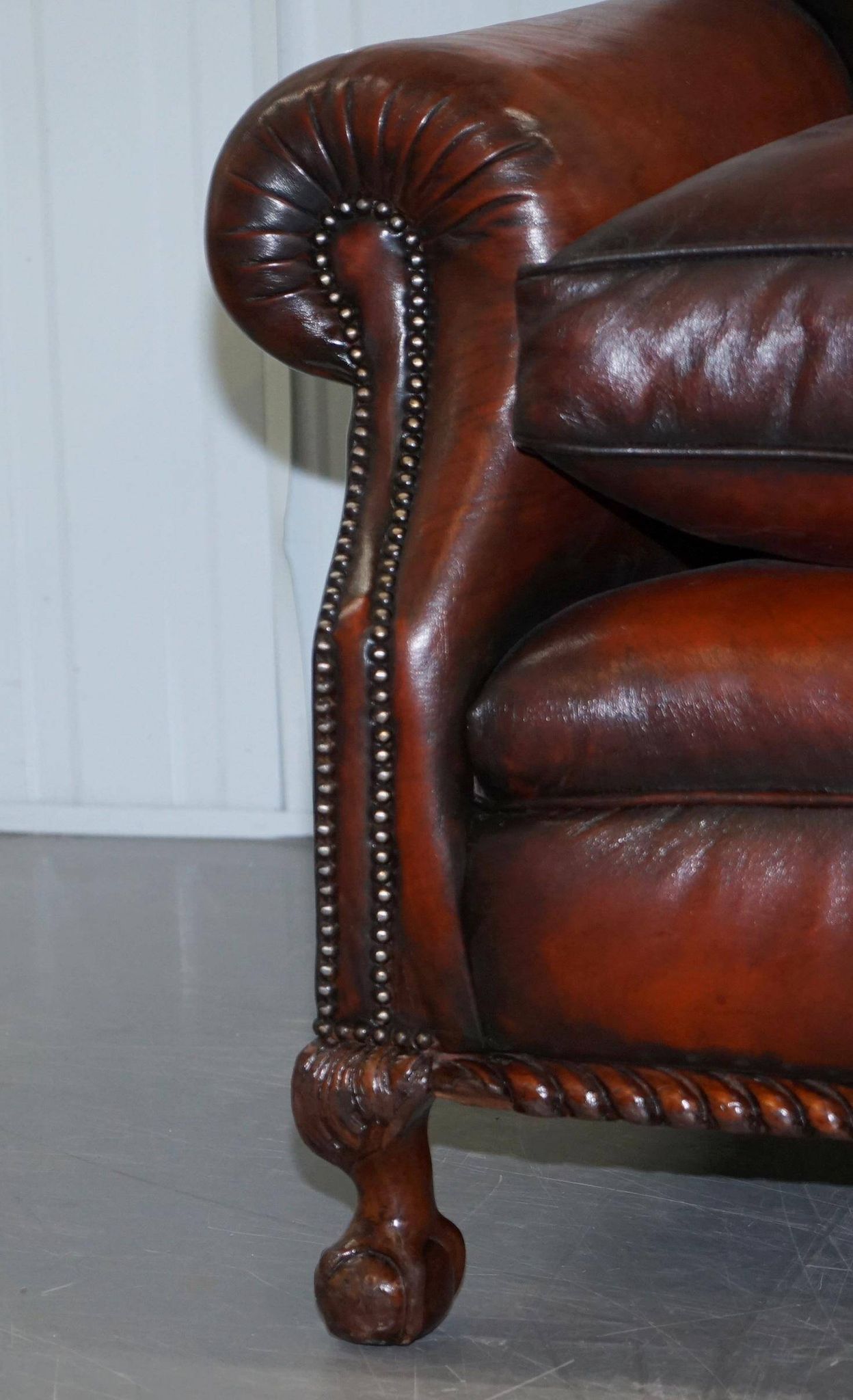 Restored Victorian sofa in leather with claw feet and feather cushions.