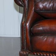 Restored Victorian sofa in leather with claw feet and feather cushions.