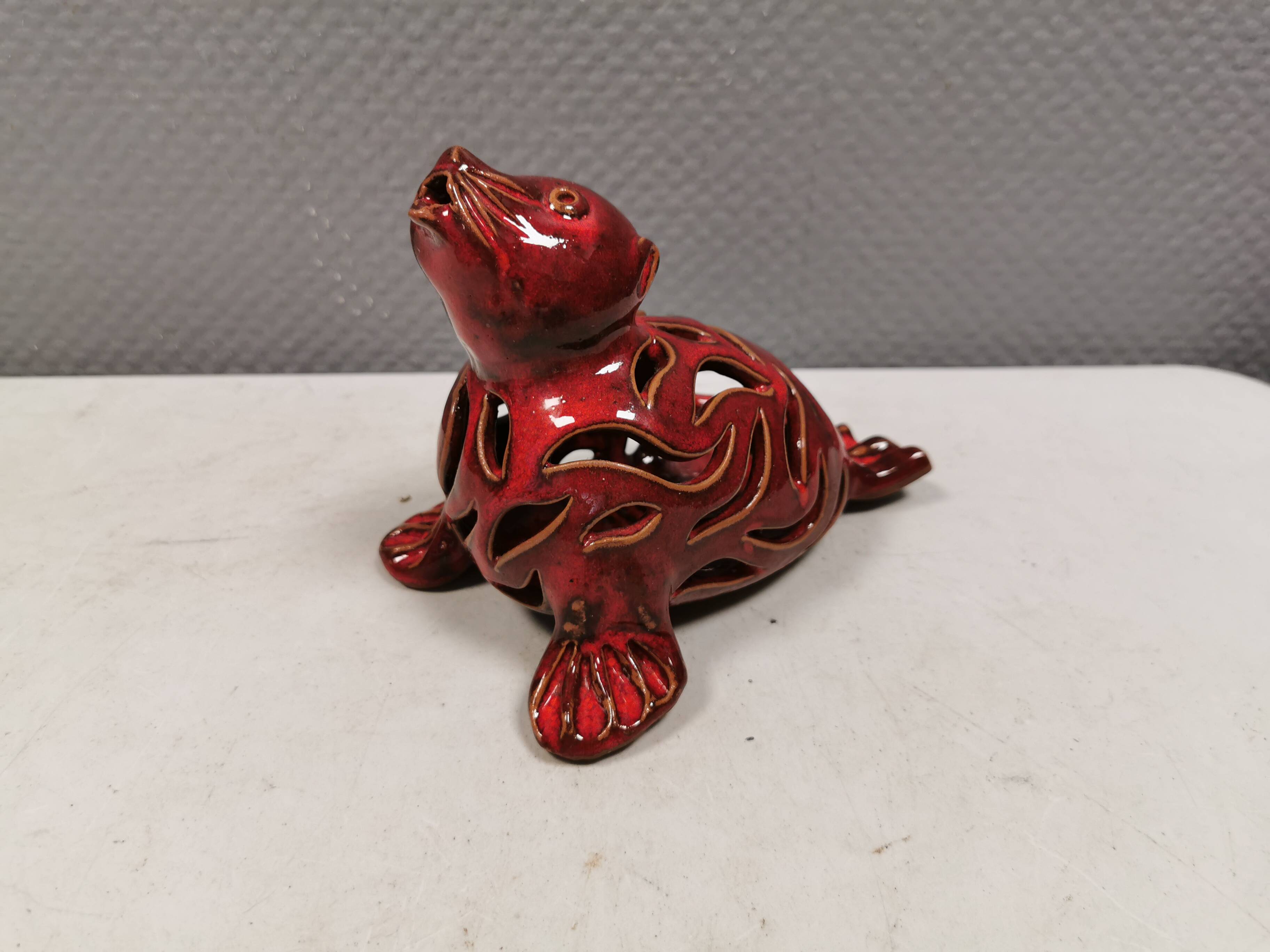 Beautiful seal in ceramic with metallic red glaze.