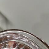 Vintage pressed molded glass plate under bottle
