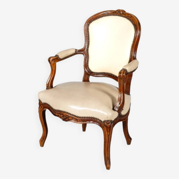 Fauteuil d’époque Louis XV en bois naturel à dossier cabriolet sculpté de fleurettes