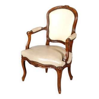 Fauteuil d’époque Louis XV en bois naturel à dossier cabriolet sculpté de fleurettes