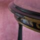 Tripod stool in blackened wood with painted floral decoration.