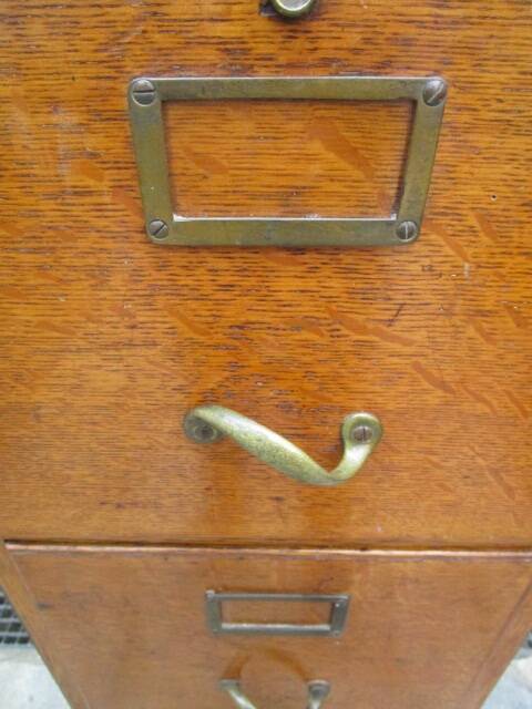 Antique oak filing cabinet with 4 drawers.