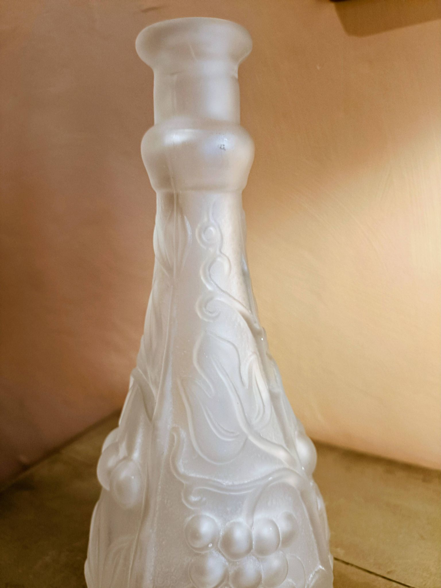 Frosted transparent glass carafe with raised cherry and grape patterns.