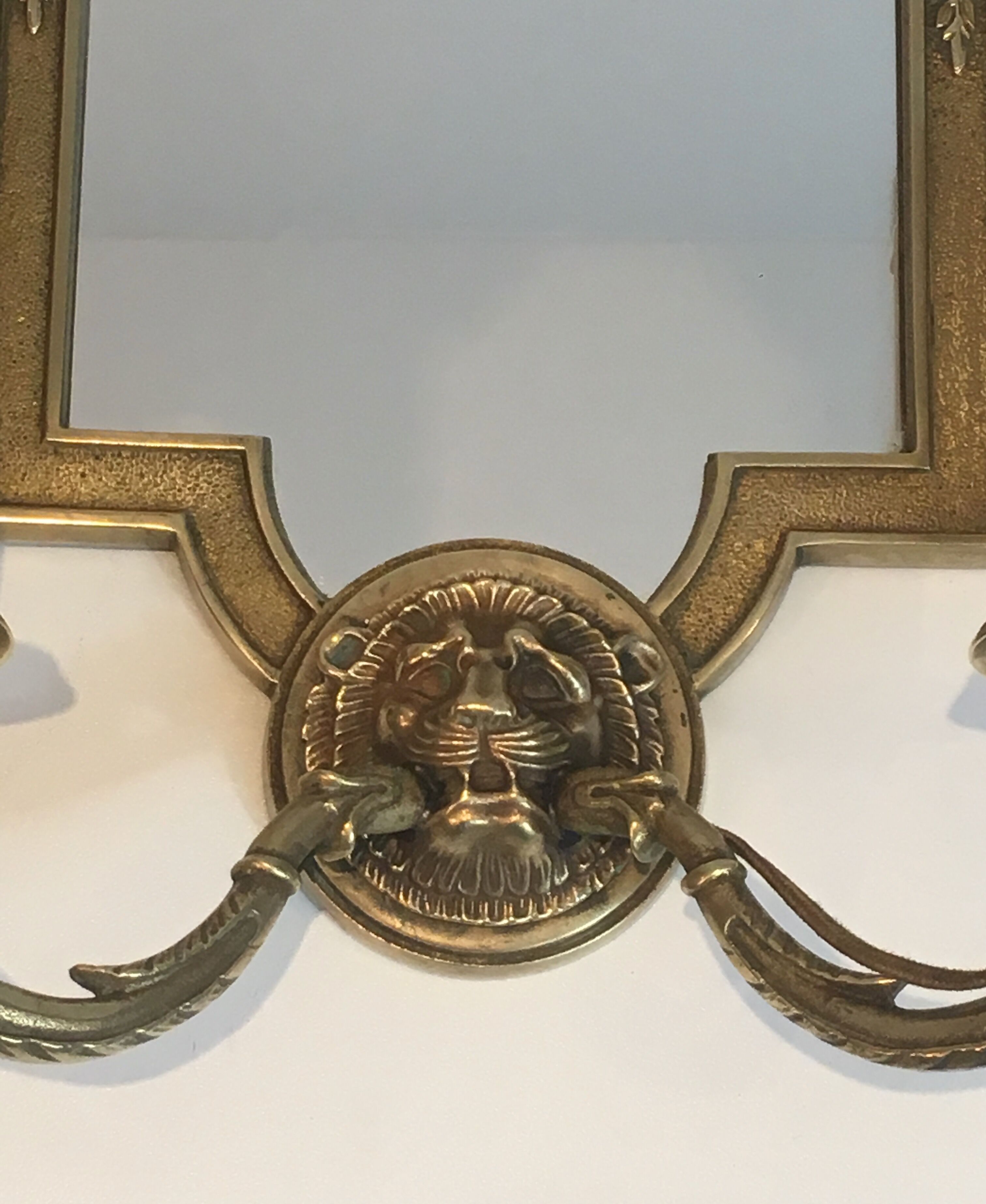 Pair of mirror and bronze wall lamps with lions' heads, french work. around 1940