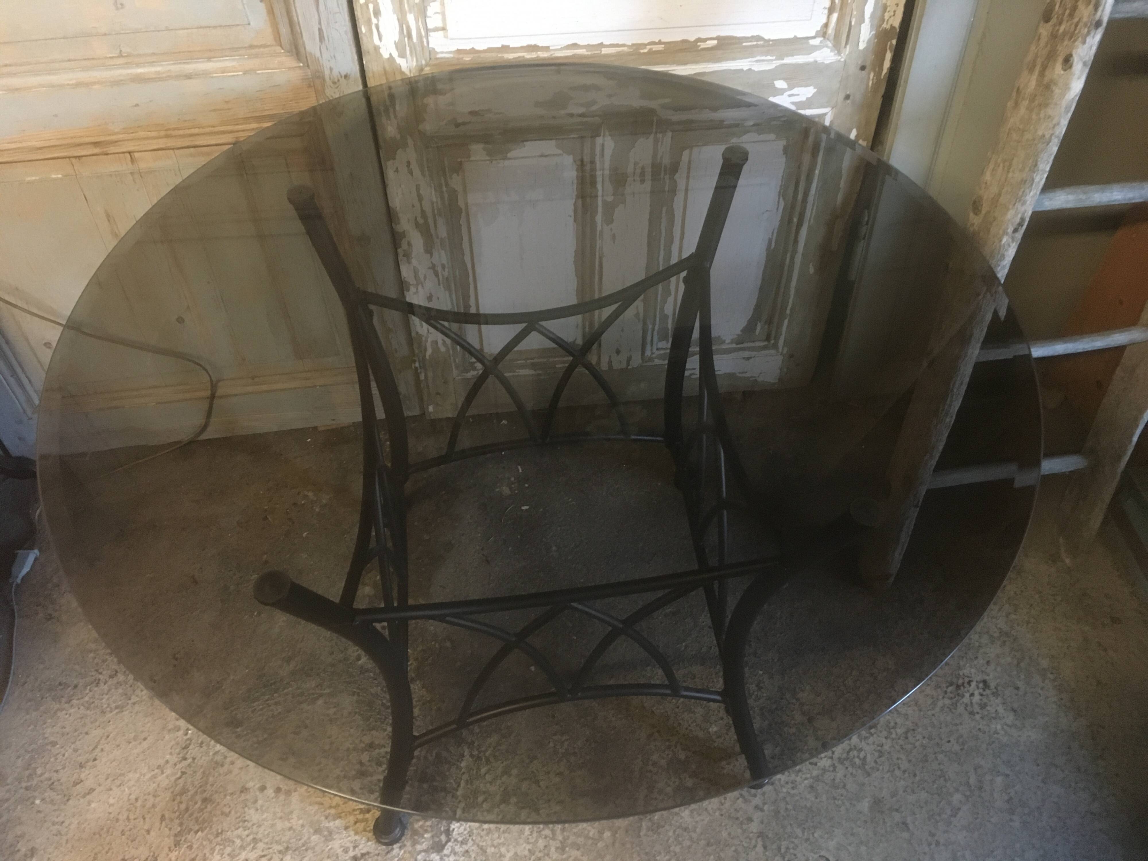 Round table with metal legs and smoked glass