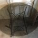 Round table with metal legs and smoked glass.