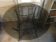Round table with metal legs and smoked glass.
