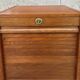 Vintage wooden filing cabinet with curtains.