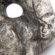 Ceramic vase sculpture decorated with faces and featuring a hole, 1980s.
