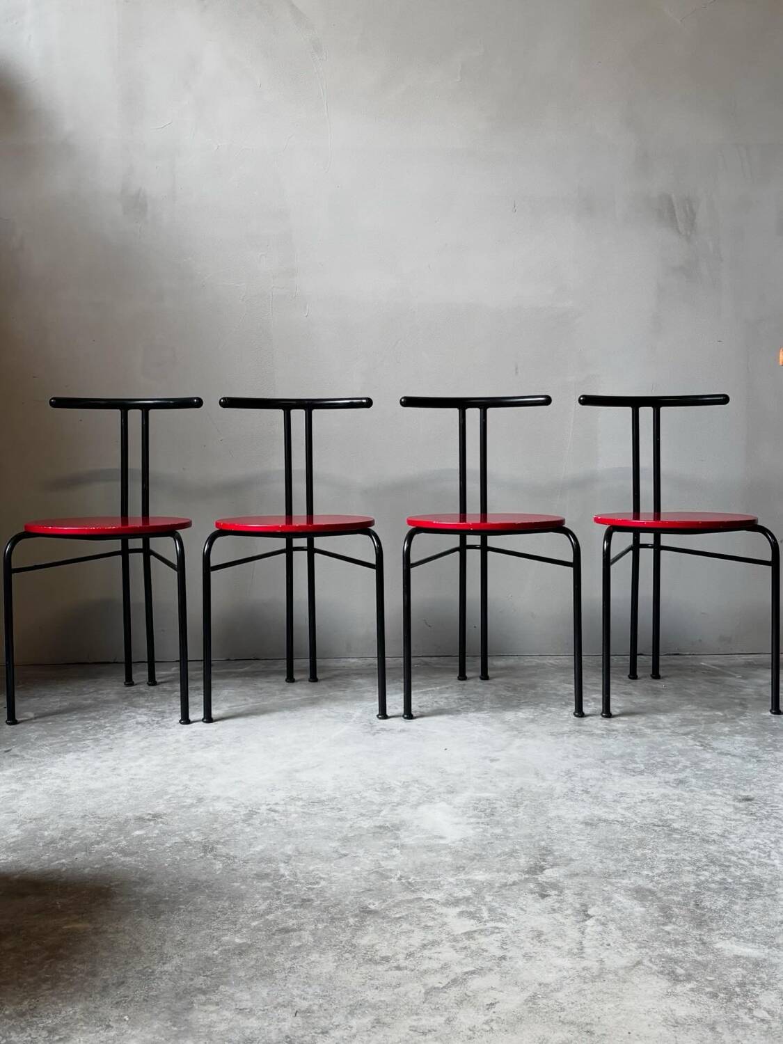 Set of 4 vintage black metal chairs with red lacquered seats.