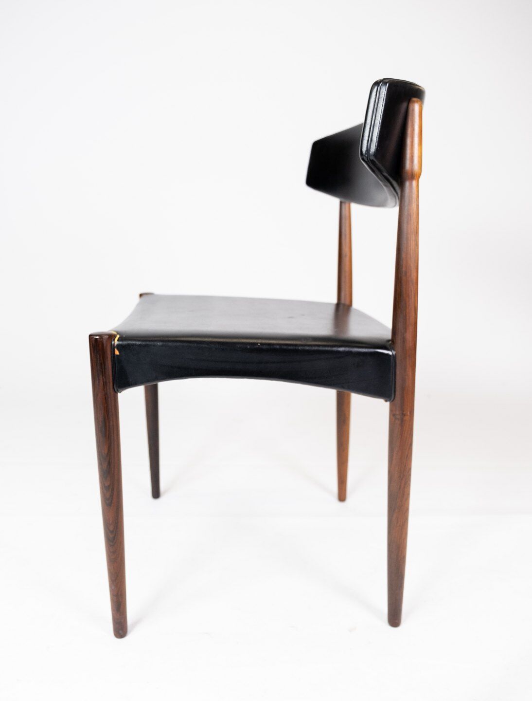 Set of four dining room chairs in rosewood and black leather of danish design from the 1960s.