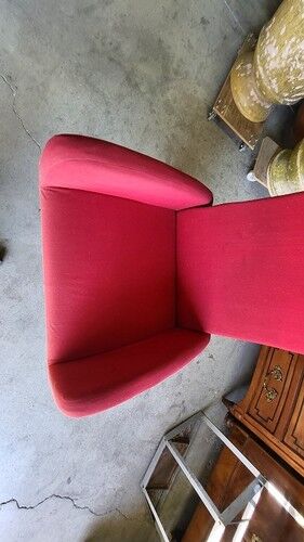 Old cinema chair with a red reclining seat.